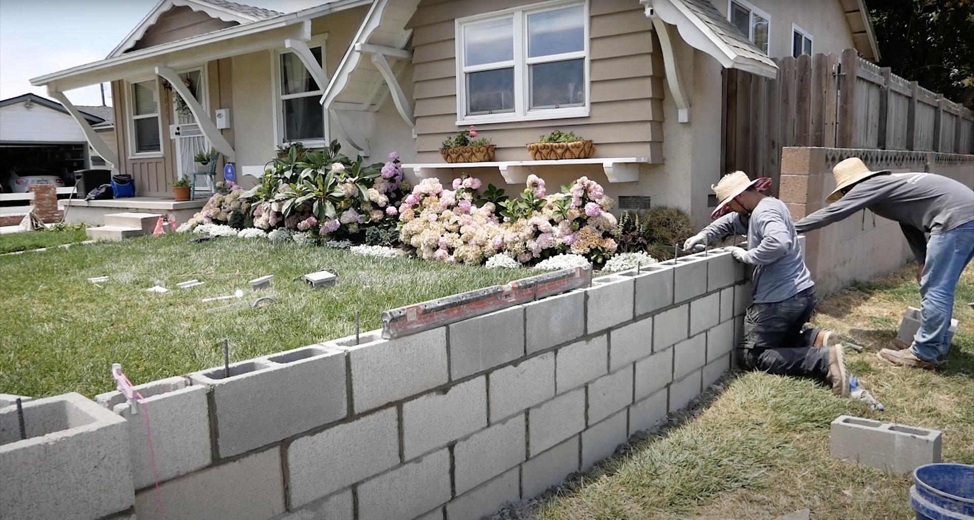 Expert retaining wall construction with professional masonry techniques Professional concrete contractors building decorative retaining wall with block installation