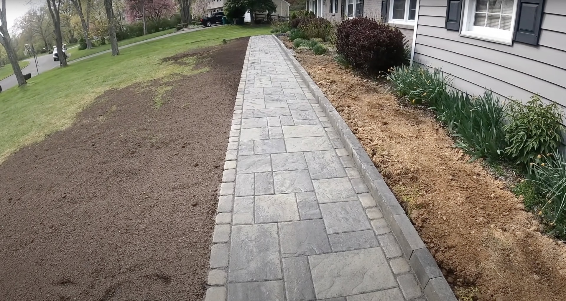 Custom stamped concrete walkway installation with decorative stone texture Beautiful stamped concrete walkway with decorative stone pattern and professional landscaping